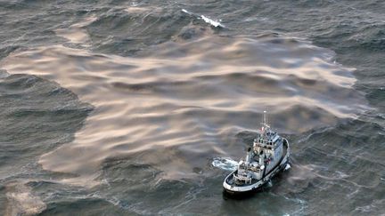 Un remorqueur tente d'aspirer une nappe de fioul &eacute;chapp&eacute;e de l'"Erika", le 15 d&eacute;cembre 2012, au large de la Bretagne. (VALERY HACHE / AFP)