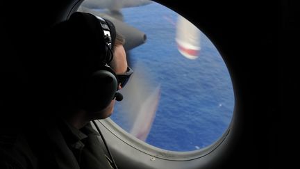 Un membre de l'aviation n&eacute;o-z&eacute;landaise participe aux recherches du vol MH370, disparu d&eacute;but mars, au large de l'Australie, le 13 avril 2014. (GREG WOOD / AFP)