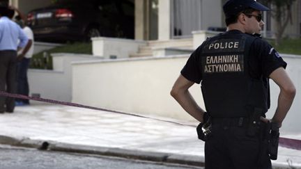 Un policier devant le domicile du journaliste Socratis Guiolas, assassiné lundi 19 juillet 2010 à Athènes. (AFP - Angelos Tzortzinis)