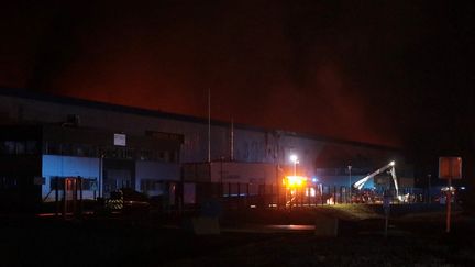 Un incendie s'est déclaré dans un bâtiment industriel loué par Bolloré Logistics, à Grand-Couronne, près de Rouen (Seine-Maritime), le 16 janvier 2023. (LOU BENOIST / AFP)