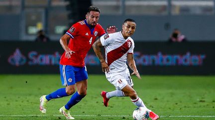 Le Chilien Mauricio Isla et le Péruvien Yoshimar Yotun&nbsp;à la lutte pour le ballon lors du match de qualification pour la Coupe du monde 2022, le 7 octobre 2021.&nbsp; (FERNANDO ZANGANA / AFP)