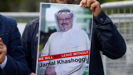 Un homme tient un&nbsp;portrait du journaliste Jamal Khashoggi devant le consulat d'Istanbul (Turquie), le 5 octobre 2018. (OSMAN ORSAL / REUTERS)