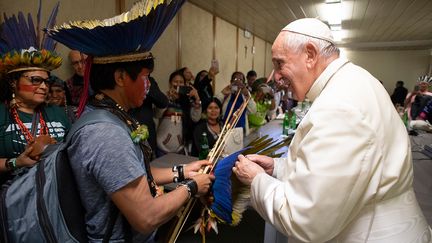 Le pape François reçoit un cadeau lors de sa rencontre avec des représentants de certains groupes ethniques de la forêt amazonienne au Vatican,le 17 octobre 2019. (HANDOUT / VATICAN MEDIA)