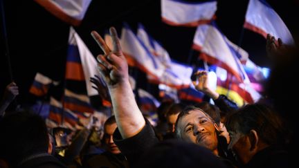 Des habitants de Crim&eacute;e f&ecirc;tent le r&eacute;sultat du r&eacute;f&eacute;rendum rattachant la p&eacute;ninsule &agrave; la Russie, le 16 mars 2014 &agrave; Simferopol.&nbsp; (DIMITAR DILKOFF / AFP)