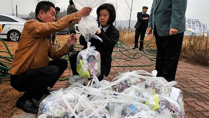 En plus des tracts, les ballons transportent aussi 5000 préservatifs masculins, des serviettes hygiéniques, des lampes électriques, des bonbons, des sous-vêtements, des chaussettes et du dentifrice. Tous ces produits sont très difficiles à se procurer au Nord en raison d’une économie défaillante et des sanctions internationales liées au programme nucléaire de Pyongyang. (AFP PHOTO / JUNG YEON-JE )