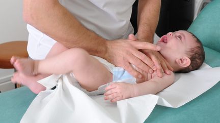 Un kinésithérapeuthe s'occupe d'un enfant atteint de bronchiolite, le 7 janvier 2010 à Saint-Etienne (Loire). (MAXPPP)