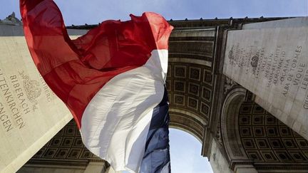 Le drapeau fran&ccedil;ais flotte sous l'Arc de triomphe, lors des c&eacute;r&eacute;monies de comm&eacute;moration de la fin de la premi&egrave;re guerre mondiale, le 11 novembre 2013, &agrave; Paris. (AFP)