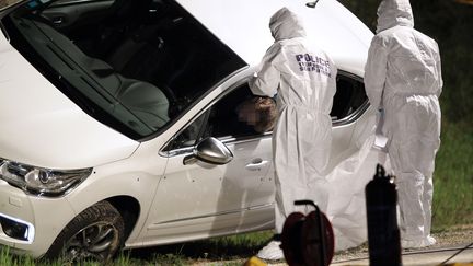 Des enqu&ecirc;teurs de la police scientifique examinent la voiture de Jean Leccia, haut fonctionnaire tu&eacute; le 23 mars 2014 &agrave; Aleria (Haute-Corse). (PASCAL POCHARD CASABIANCA / AFP)