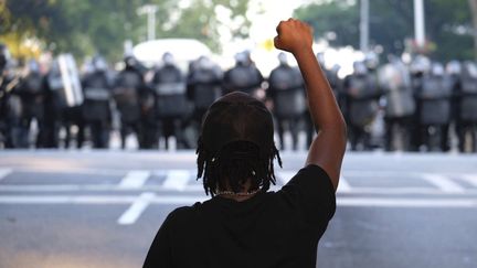 Un manifestant lève le poing le 1er juin à Atlanta face à la police, après la mort de l'Afro-américain George Floyd lors d'une interpellation le 25 mai à Minneapolis. (BEN GRAY / AP / SIPA)