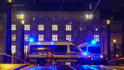 Des véhicules de police sur un pont face au bâtiment universitaire où un tireur a tué plus de 15 personnes, à Prague (République tchèque), le 21 décembre 2023. (PETR DAVID JOSEK / AP / SIPA)