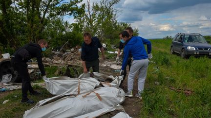 Les corps de militaires russes sont récupérés dans une tranchée près du village de Malaya Rogan, pour les enterrer dans des sacs mortuaires dans la région de Kharkiv, le 18 mai 2022.&nbsp; (SOFIA BOBOK / ANADOLU AGENCY)