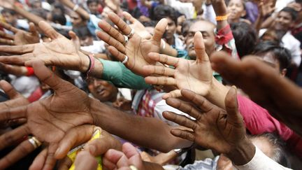 Des fid&egrave;les hindous tendent les bras pour attraper de la nourriture distribu&eacute;e dans le cadre du festival&nbsp;Rath Yatra &agrave; Ahmedabad (Inde), le 10 juillet 2013. (AMIT DAVE / REUTERS)