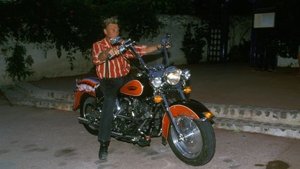 Johnny Hallyday sur une moto Harley-Davidson à Saint Tropez en 1990. (POOL REGLAIN/STEVENS / GAMMA-RAPHO)