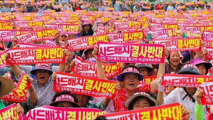 Des milliers d'habitants du comté de Seongju, à environ 200 km au sud-est de Séoul où il sera installé, ont fait entendre leurs voix le 13 juillet 2016, en brandissant des pancartes proclamant leur «opposition absolue au déploiement de THAAD», selon l'agence sud-coréenne Yonhap. Certains ont entamé une grève de la faim, d'autres se sont entaillé les doigts pour écrire des slogans en lettres de sang. Située sur un site de production de melons, cette installation va, selon eux, avoir des répercussions économiques et environnementales. Les opposants y voient une «menace pour les conditions de vie des 45.000 habitants du comté, dont 60% cultivent le melon». Depuis le 4e essai nucléaire nord-coréen du 6 janvier 2016, les tensions ne cessent de s'aggraver dans la péninsule. (YONHAP / AFP)