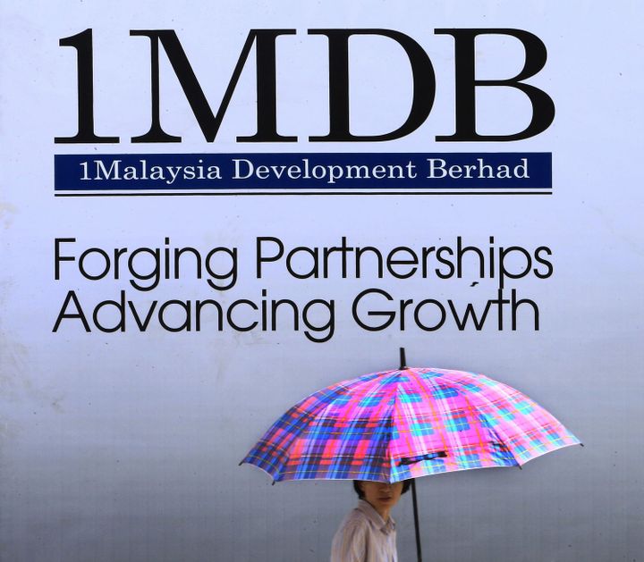 Une femme passe devant une affiche du fonds d'investissement 1 Malaysia Development Berhad (1MDB) à Kuala Lumpur (Malaisie) le 27 janvier 2014. (REUTERS/Samsul Said)