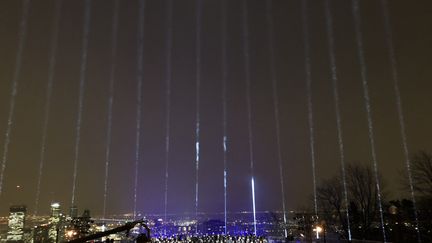 Quatorze faisceaux ont illuminé, vendredi 6 décembre, le ciel de Montréal (Canada) en mémoire des 14 femmes tuées il y a 30 ans à l'Ecole polytechnique de la métropole québécoise. (ANNE-SOPHIE THILL / AFP)