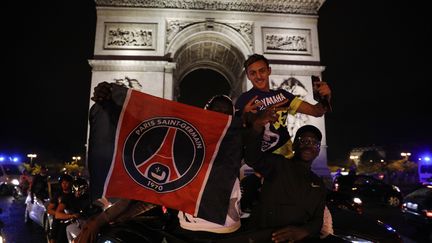 Les supporters du Paris Saint-Germain célèbrent la qualification en finale de la Ligue des champions avenue des Champs-Élysées près de l'Arc de Triomphe à Paris, le 18 août 2020. (GEOFFROY VAN DER HASSELT / AFP)