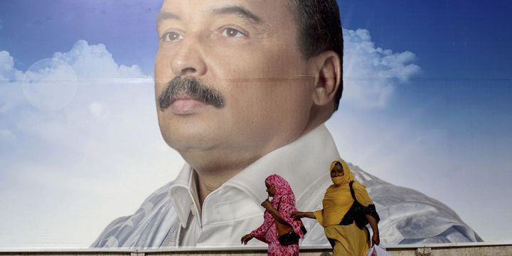 Des femmes passent devant une affiche du président Mohamed Ould Abdel Aziz à Nouakchott, le 18 juin 2014. (REUTERS / Joe Penney)