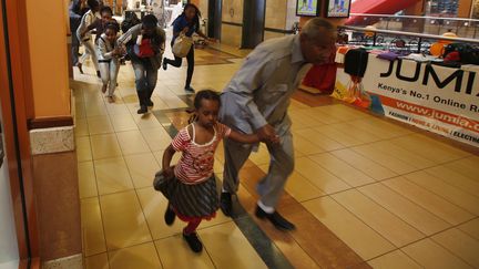 Des personnes fuient l'attaque terroriste dans le centre commercial Westgate &agrave; Nairobi, au Kenya, le 22 septembre 2013. (GORAN TOMASEVIC / REUTERS)