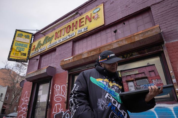 Danny Cortes tient dans ses mains une miniature de Ho May Kitchen dans le quartier de Brooklyn à New York le 19 décembre 2022. (YUKI IWAMURA / AFP)