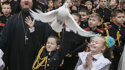 Un jeune cadet l&acirc;che dans les airs une colombe &agrave; l'occasion d'une c&eacute;r&eacute;monie militaire &agrave; Kiev (Ukraine), le 14 novembre 2014. ( GLEB GARANICH / REUTERS)