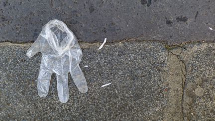 Illustration d'un gant en plastique jeté dans la rue à Paris, le 16 mai 2020. (SEBASTIEN MUYLAERT / MAXPPP)