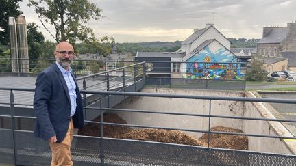 Jean-Marc Labbé, maire de La Méaugon (Côtes-d'Armor) devant la chaudière bois de la commune.&nbsp; (MATHILDE GRACIA/ FRANCEINFO)