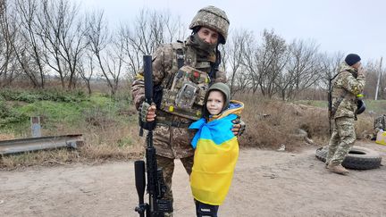 Danya, 7 ans, prend la pose avec un soldat, à Kherson, le dimanche 13 novembre 2022. (AGATHE MAHUET / RADIO FRANCE)