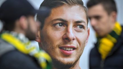 Des supporters du FC Nantes se tiennent à côté d'un portrait de l'attaquant argentin Emiliano Sala,&nbsp; le 24 janvier 2019, trois jours après sa disparition. (LOIC VENANCE / AFP)