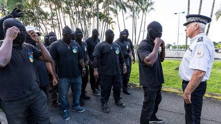 Un manifestant du collectif des 500 Frères fait face à un policier à Cayenne, le 29 mars 2017, lors d'un rassemblement.&nbsp; (JODY AMIET / AFP)