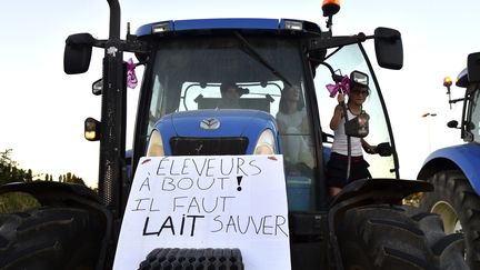 Une femme sur un tracteur, devant la siège de Lactalis, à Laval (Mayenne), le 22 août 2016.&nbsp; (JEAN-FRANCOIS MONIER / AFP)