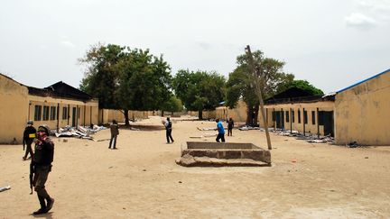 Des policiers marchent dans le lyc&eacute;e de Chibok, o&ugrave; ont &eacute;t&eacute; enlev&eacute;es les quelque 200 adolescentes nig&eacute;rianes, mi-avril. (STR / AFP)