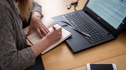 Une salariée note ses jours de vacances sur son agenda. Photo d'illustration. (JULIEN MARSAULT / HANS LUCAS)