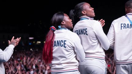 Les judokates Clarisse Agbégnénou et Sarah Léonie Cysique célèbrent le titre olympique par équipes au Club France, à Paris, le samedi 3 août 2024. (LAURIN AMELIE / KMSP via AFP)