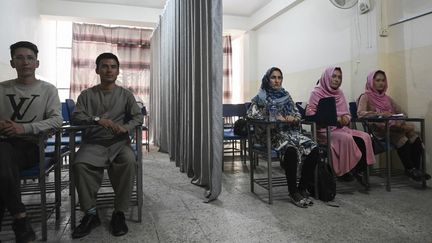 Des étudiants et des étudiantes afghanes&nbsp;séparés par un rideau, le 7 septembre 2021 dans une université privée de Kaboul (Afghanistan). (AAMIR QURESHI / AFP)