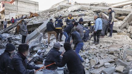 Des sauveteurs fouillent les décombres à la recherche de victimes et de survivants dans le village d'Azmarin, dans la province d'Idlib, au nord-ouest de la Syrie, tenue par les rebelles, à la frontière avec la Turquie, le 7 février 2023. (OMAR HAJ KADOUR / AFP)
