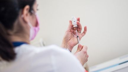 Une femme manipule une seringue et un flacon du vaccin d'Astra Zeneca contre le Covid-19, à La Baule (Loire-Atlantique), le 6 mars 2021. (BAPTISTE ROMAN / HANS LUCAS / AFP)