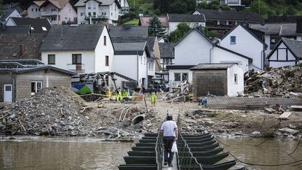 Un homme traverse un pont temporaire à Rech, village situé&nbsp;en&nbsp;Rhénanie-Palatinat (Allemagne), le 30 juillet 2021. (BERND LAUTER / AFP)