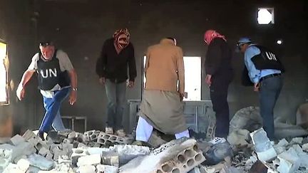 Capture d'image d'une vid&eacute;o de la mission d'observation de l'ONU du 8 juin en Syrie et r&eacute;alis&eacute;e &agrave; Al-Koubeir. Des observateurs inspectent des ruines. ( ISSEI KATO / AFP)