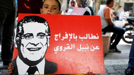 Un gamin tient une affiche du candidat Nabil Karoui lors d'une manifestation de soutien à l'homme d'affaires emprisonné pour "blanchiment", le 3 septembre 2019 à Tunis. (ZOUBEIR SOUISSI / X02856)