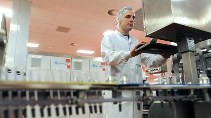 Un homme travaille sur une ligne de production de vaccins, le 16 d&eacute;cembre 2011, dans une usine de&nbsp;GlaxoSmithKline &agrave; Saint-Amand-les-Eaux (Nord).&nbsp; (FRANCOIS LO PRESTI / AFP)