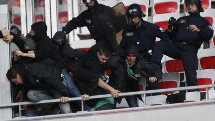 Des supporters de Saint-Etienne sont ma&icirc;tris&eacute;s par des CRS, le 24 novembre 2013, &agrave; Nice (Alpes-Maritimes). (VALERY HACHE / AFP)