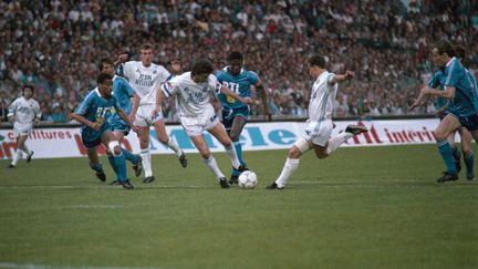 Les Marseillais Franck Sauzée, Philippe Vercruysse et Jean-Pierre Papin (de gauche à droite, en blanc) à l'assaut de la défense du PSG, le 5 mai 1989 au Stade-Vélodrome de Marseille (Bouches-du-Rhône). (RICHARD BARSOTTI / AFP)