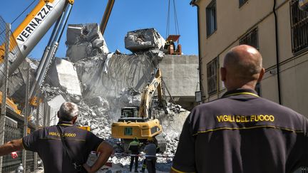 Des pompiers participent aux opérations de secours sur les lieux de l'effondrement du viaduc Morandi de Gênes (Italie), jeudi 16 août 2018. (PIERO CRUCIATTI / AFP)