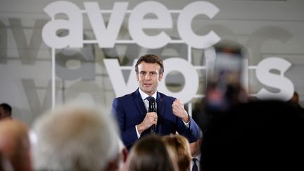 Le président de la République, Emmanuel Macron, lors d'une "conversation" avec des habitants de Poissy (Yvelines) le 27 mars 2022 (LUDOVIC MARIN / AFP)