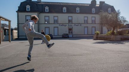 Deux élèves du collège Jean-Paul II à Ploemeur (Morbihan) jouent au foot dans la cour de récréation, le&nbsp;24 mars 2020. (MANON CAVERIBERE / HANS LUCAS / AFP)