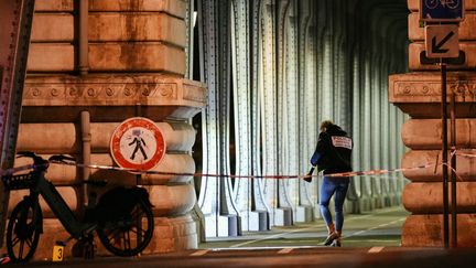 Une policière au niveau du Pont de Bir Hakeim à Paris après une attaque au couteau qui a fait un mort et deux blessées, le 2 décembre 2023. (DIMITAR DILKOFF / AFP)