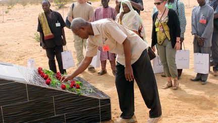 Parents et familles burkinabe et français du crash d'Air Algérie AH5017 déposent des fleurs sur une stèle près du site du crash dans la région de Gossi au Mali, à l'ouest de Gao, le 21 avril 2015. (OLLO HIEN / AFP)