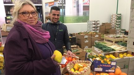 Elodie Zeiher et Christophe devant leur stand d'agrumes bios à Rungis (Laurent Mariotte / Radio France)