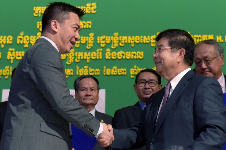 Officials of the Singapore group KrisEnergy shake hands with Cambodian Energy Minister Suy Sem on August 23, 2017, following the signing of a contract between the two parties.  (TANG CHHIN SOTHY / AFP)